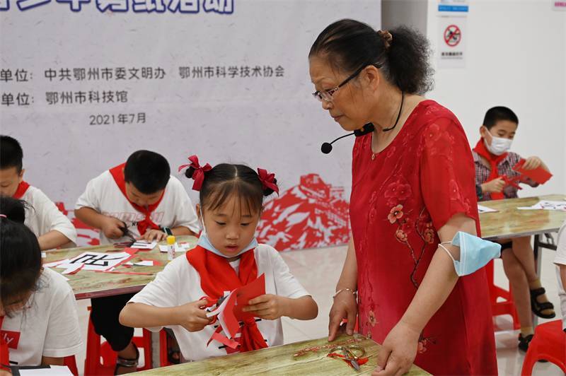 2021年7月10日，鄂州市科协组织落驾坪小学学生在鄂州市科技馆开展社会主义核心价值观系列活动，图为开展的红色剪影圆梦中华剪纸活动，老师指导同学剪纸.jpg