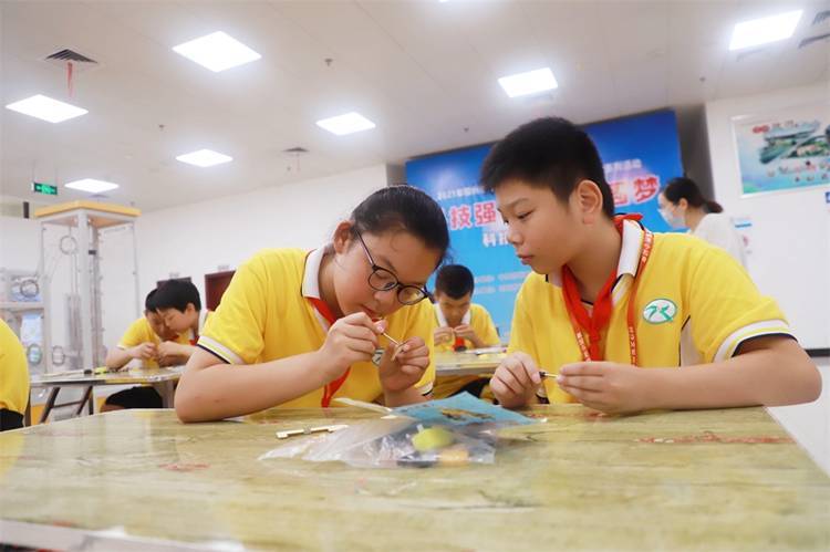 2021年7月9日鄂州市科协组织新民街小学学生在鄂州市科技馆开展社会主义核心价值观系列活动，图为开展的科技创新圆梦中华科技小制作活动，孩子们正在相互配合制作蠕虫机器人.jpg